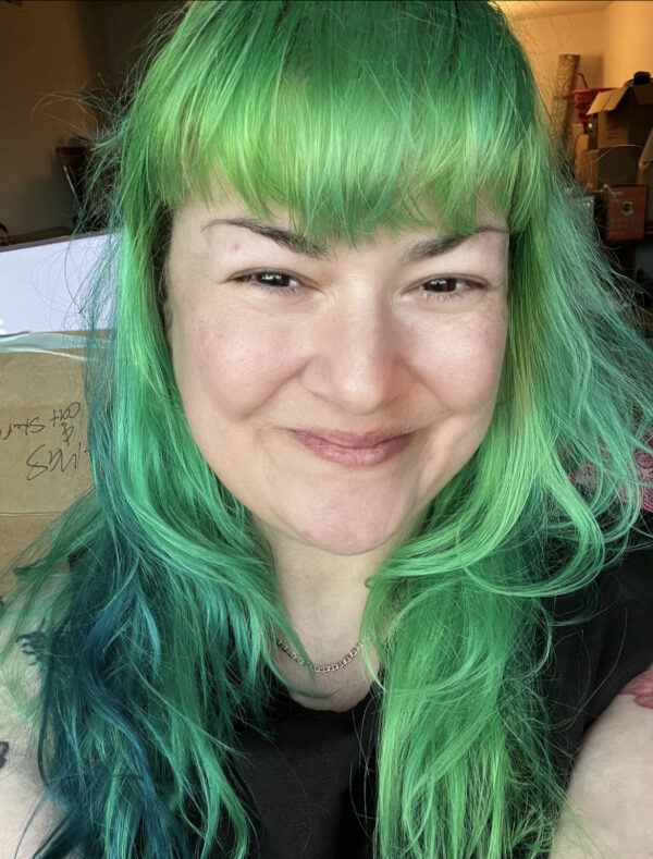 picture of a smiling woman with green hair smiling
